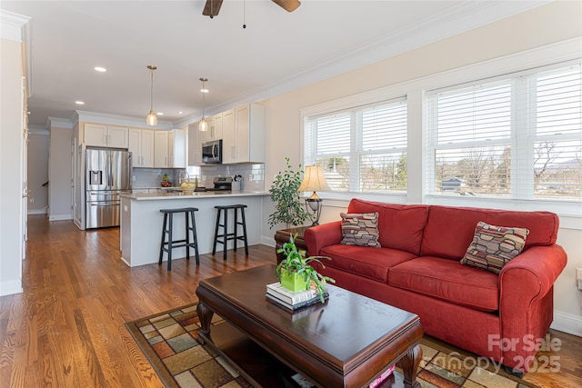 living area featuring a ceiling fan, wood finished floors, baseboards, recessed lighting, and crown molding