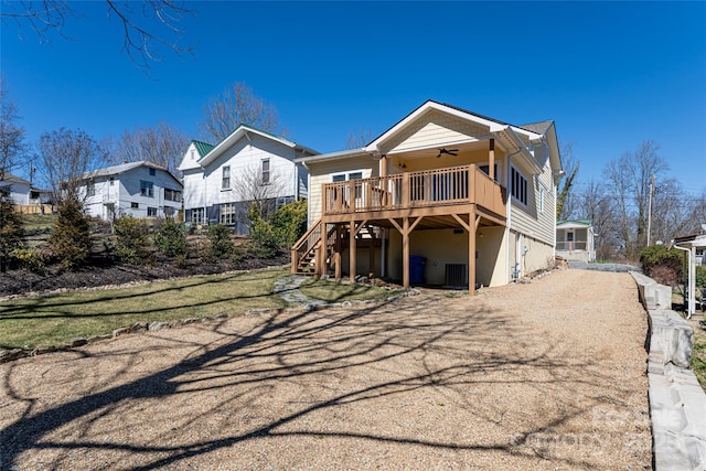 rear view of property with a deck, driveway, a ceiling fan, a residential view, and stairs