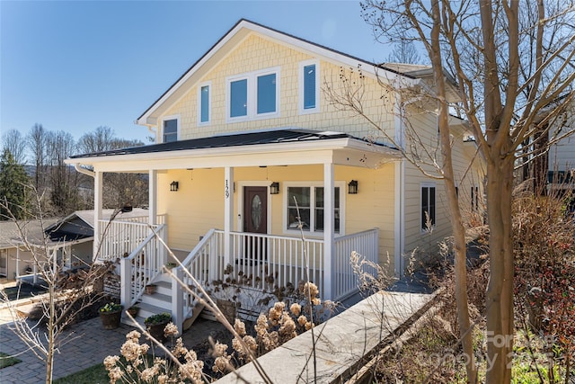 view of front facade featuring a standing seam roof, a porch, and metal roof