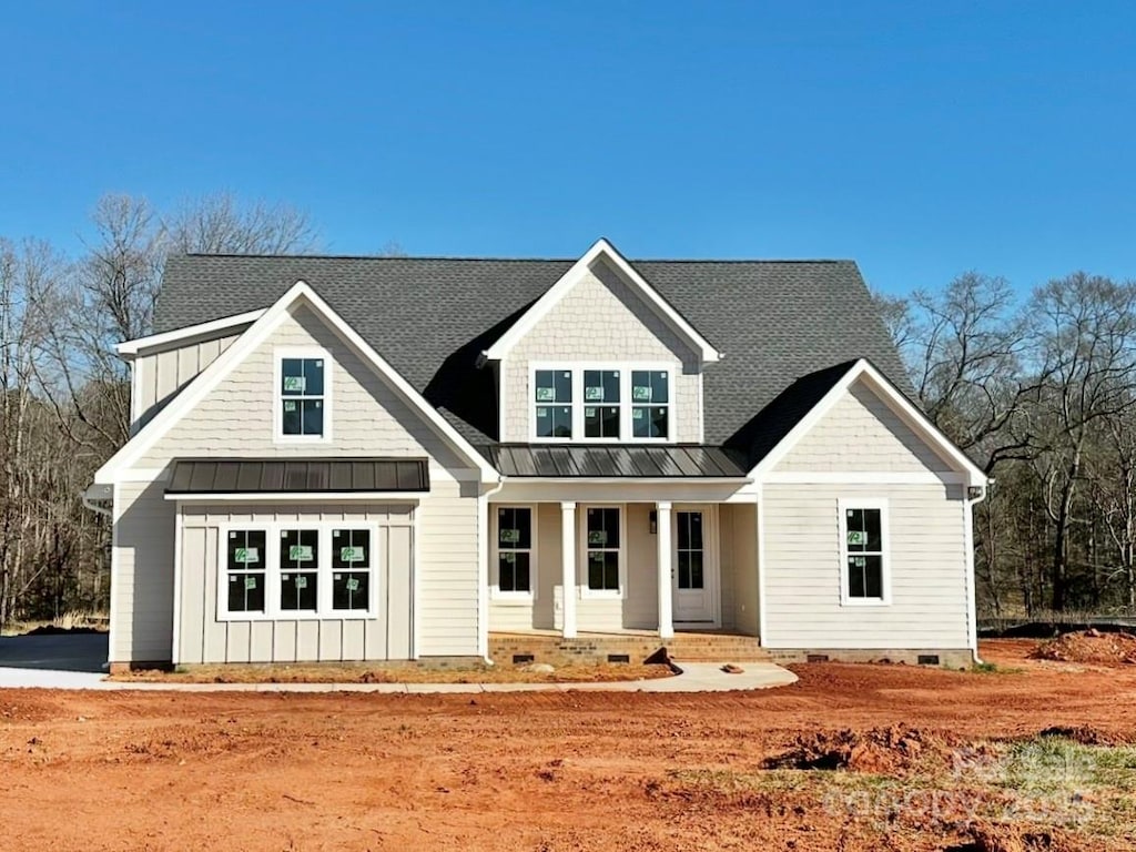 view of front of home featuring a standing seam roof, board and batten siding, covered porch, metal roof, and crawl space