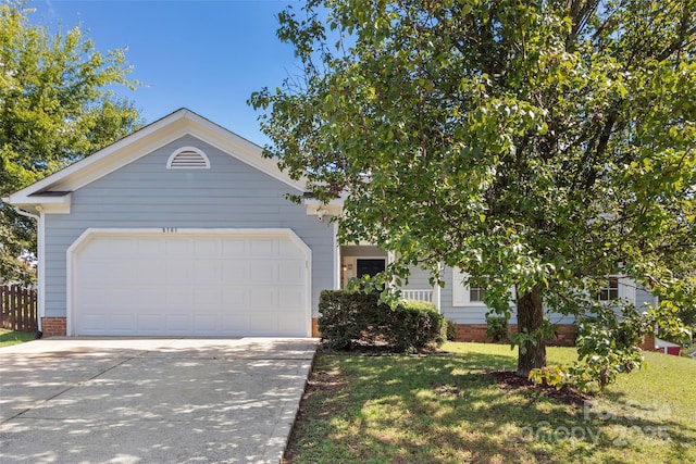 view of front facade featuring concrete driveway, an attached garage, and a front yard