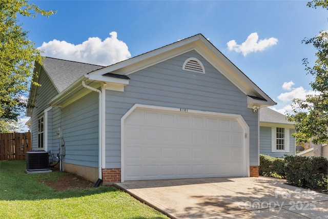 view of side of property featuring an attached garage, fence, central AC, and roof with shingles