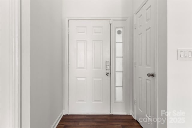 doorway to outside featuring baseboards and dark wood-type flooring