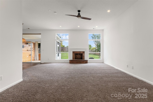 unfurnished living room featuring recessed lighting, carpet floors, a brick fireplace, and ceiling fan