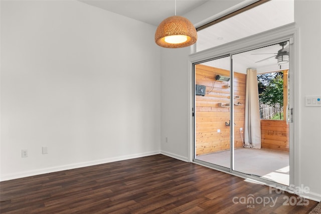 empty room featuring dark wood-style floors and baseboards