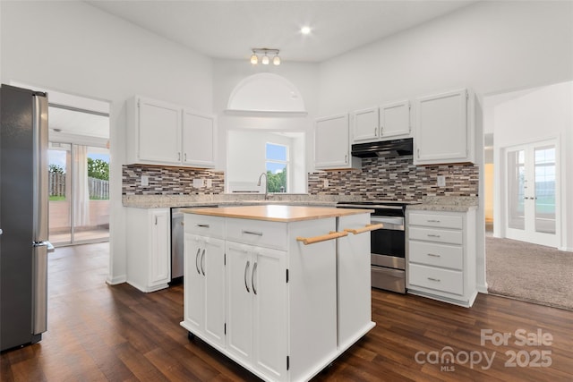 kitchen with light countertops, white cabinets, under cabinet range hood, and stainless steel appliances