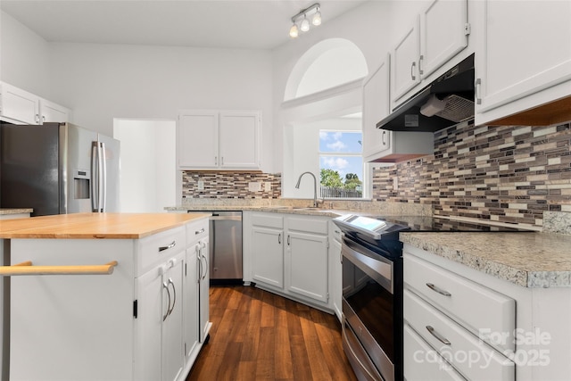 kitchen with under cabinet range hood, dark wood finished floors, stainless steel appliances, white cabinets, and wooden counters