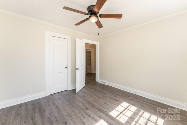 unfurnished bedroom with ceiling fan, baseboards, ornamental molding, wood finished floors, and a closet