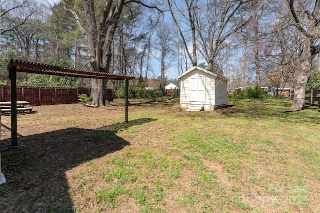 view of yard with a storage shed, an outbuilding, and fence