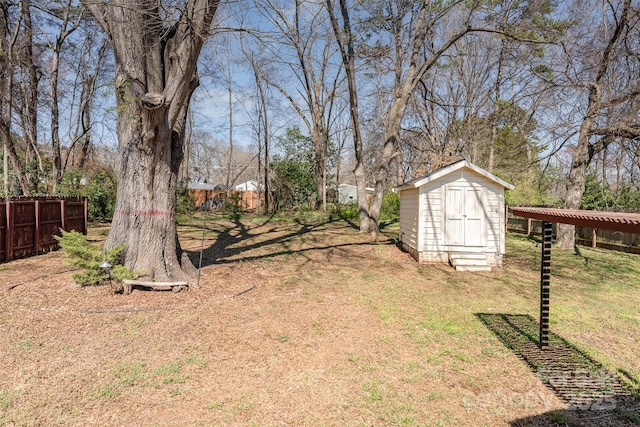 view of yard with an outbuilding, a storage shed, and fence