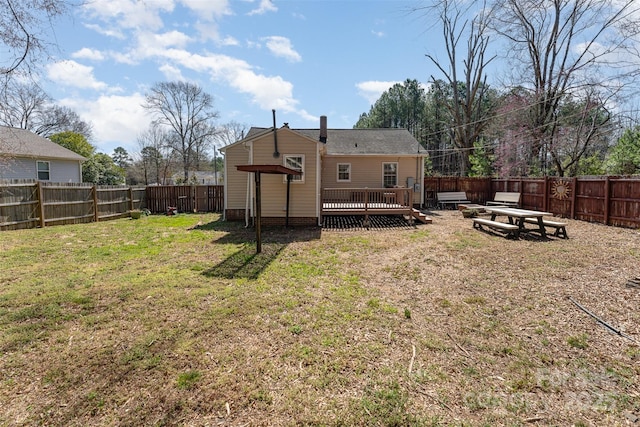 back of house with a wooden deck, a yard, and a fenced backyard