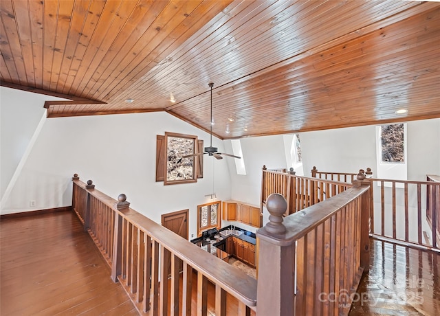 hall featuring wood ceiling, an upstairs landing, lofted ceiling, and wood finished floors