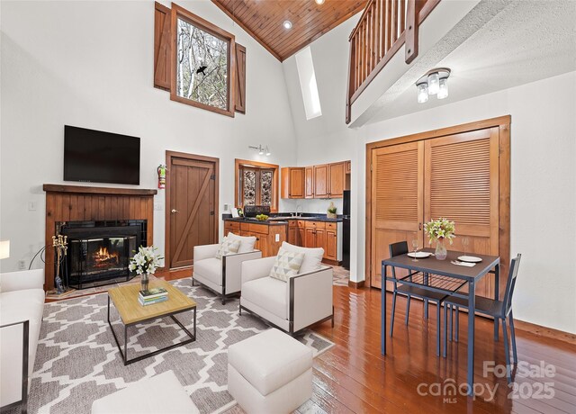 50 Cottontail Ln, Canton, NC 28716 - living room with high vaulted ceiling, hardwood / wood-style flooring, a glass covered fireplace, wooden ceiling, and baseboards