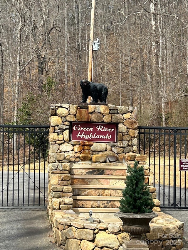 community sign featuring a gate and fence