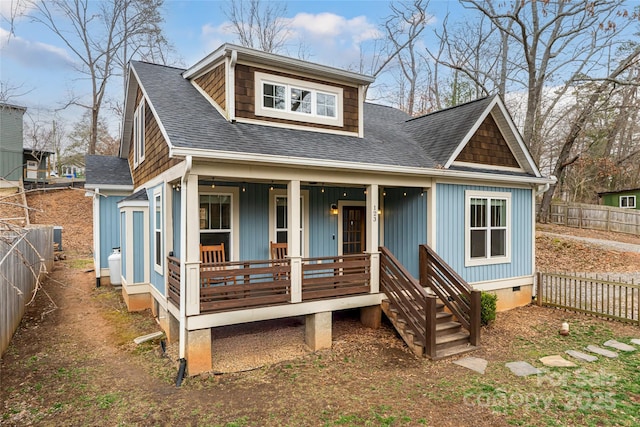 view of front facade with a shingled roof, a porch, a fenced backyard, and crawl space