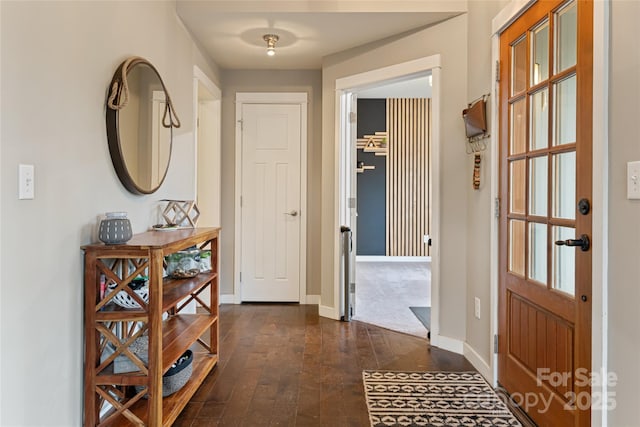 foyer with baseboards and dark wood-style flooring