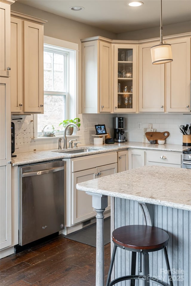 kitchen with a sink, tasteful backsplash, a breakfast bar area, dishwasher, and dark wood-style flooring