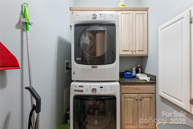 laundry room with stacked washer / dryer and cabinet space