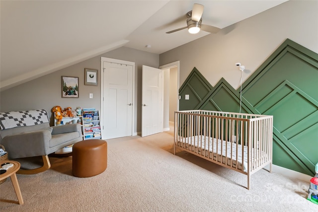 bedroom with light colored carpet, a ceiling fan, lofted ceiling, and a crib