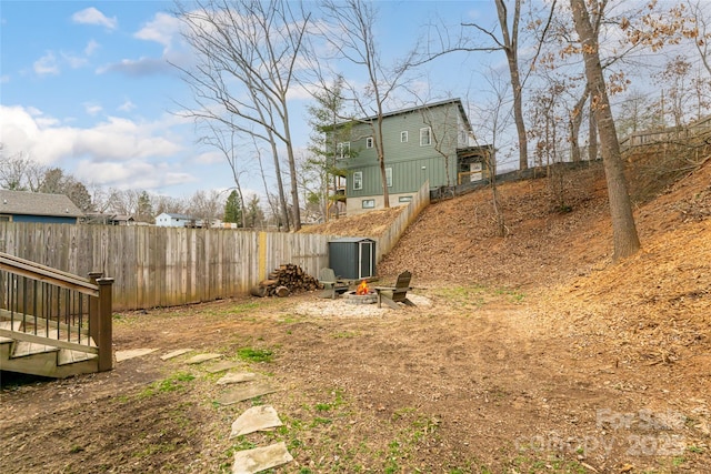 view of yard featuring a fire pit and fence