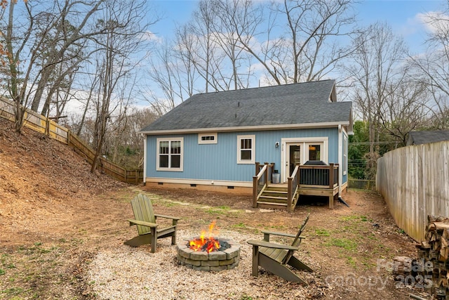 rear view of house with a fire pit, a shingled roof, french doors, a fenced backyard, and crawl space