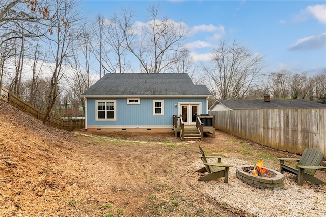 rear view of house featuring fence, french doors, a fire pit, roof with shingles, and crawl space