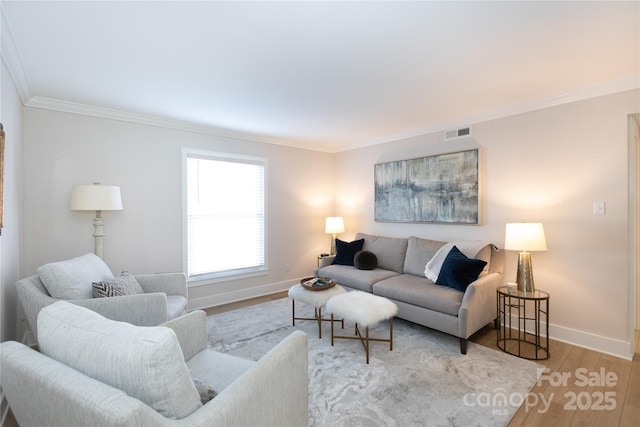 living room with visible vents, ornamental molding, baseboards, and wood finished floors