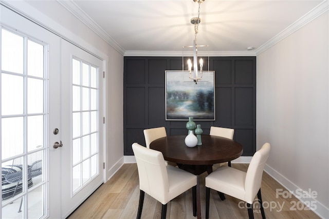 dining space featuring a decorative wall, french doors, and ornamental molding