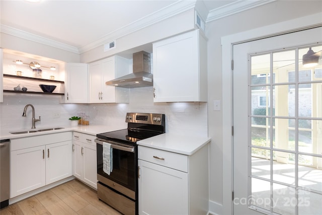 kitchen with a sink, stainless steel appliances, wall chimney exhaust hood, and crown molding