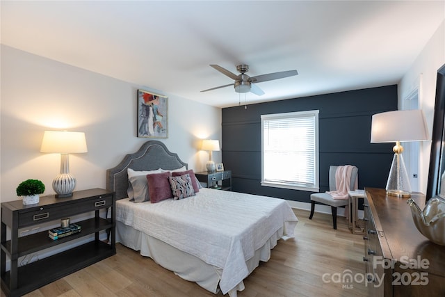 bedroom featuring a ceiling fan, light wood-type flooring, and baseboards