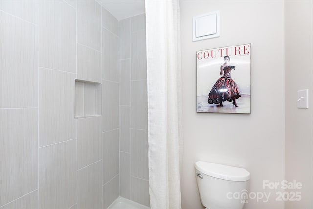 bathroom with toilet and tiled shower