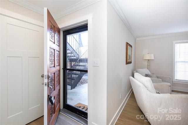 entryway featuring light wood-style flooring, baseboards, and ornamental molding