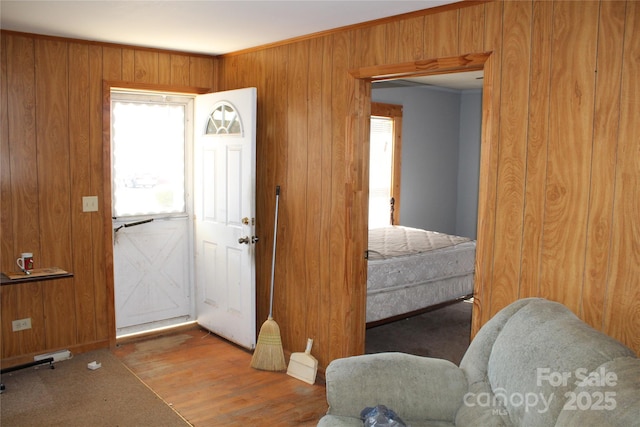 foyer with wood finished floors and wood walls