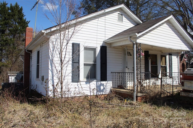 bungalow-style house with a porch and a chimney