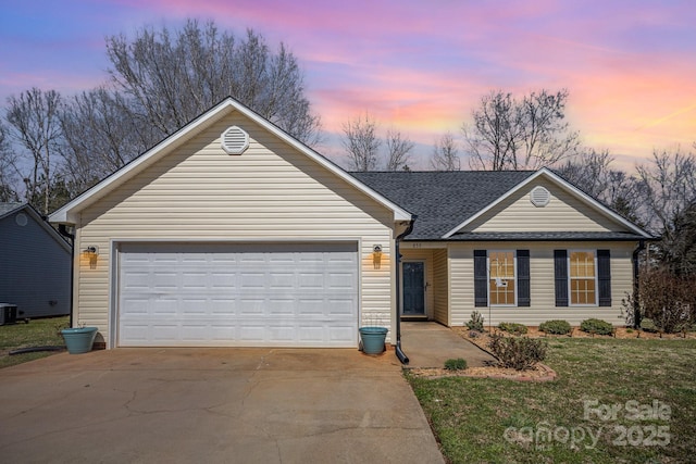 ranch-style house featuring driveway, roof with shingles, a yard, central AC, and a garage