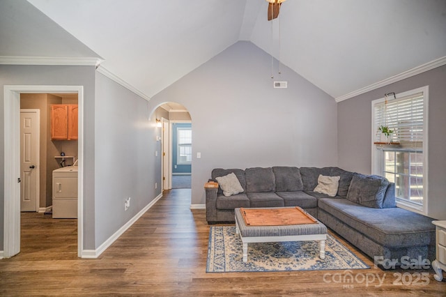 living room with arched walkways, washer / dryer, wood finished floors, and ornamental molding