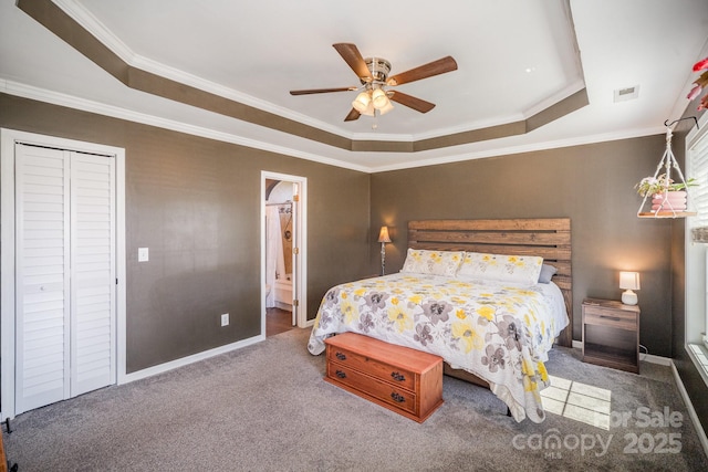 carpeted bedroom featuring visible vents, crown molding, ensuite bath, a raised ceiling, and a ceiling fan