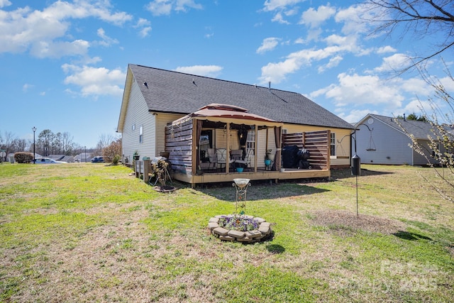 rear view of house featuring a gazebo, a deck, a shingled roof, and a yard