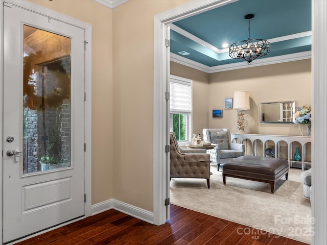 foyer with a chandelier, baseboards, dark wood finished floors, and crown molding