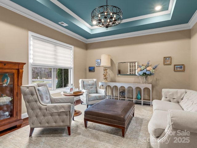 living room featuring visible vents, a raised ceiling, an inviting chandelier, and ornamental molding