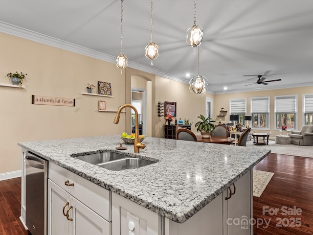 kitchen with arched walkways, a sink, stainless steel dishwasher, crown molding, and open floor plan