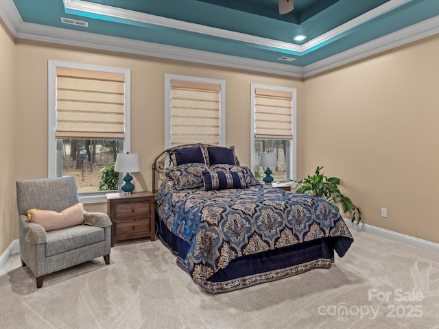 bedroom with visible vents, baseboards, carpet, a tray ceiling, and ornamental molding