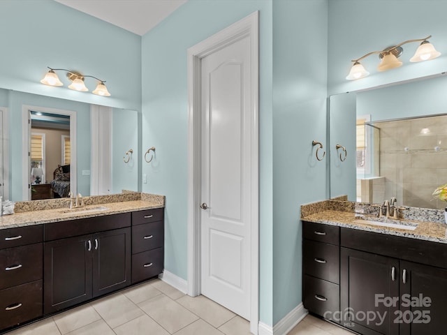 ensuite bathroom with tile patterned flooring, connected bathroom, two vanities, and a sink