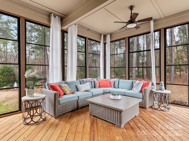 sunroom / solarium with beamed ceiling, a healthy amount of sunlight, and a ceiling fan