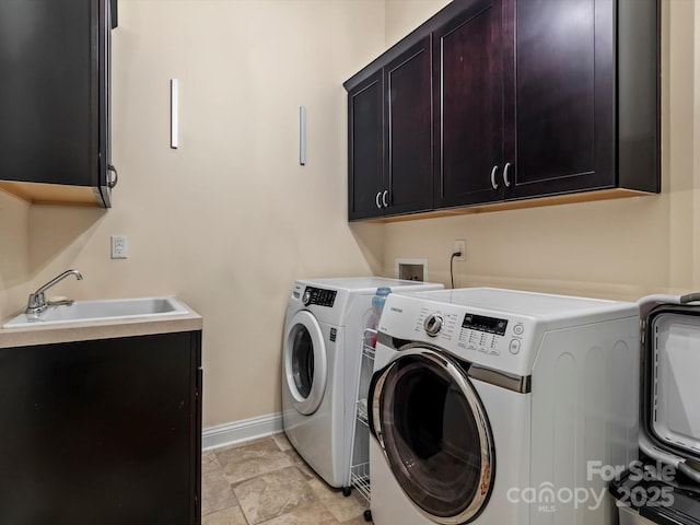 laundry area featuring washer and dryer, cabinet space, baseboards, and a sink