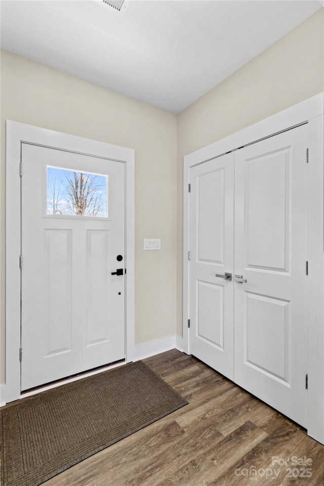 foyer featuring wood finished floors and baseboards