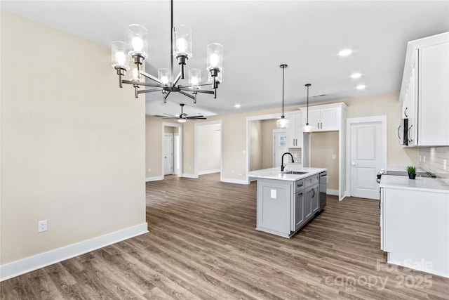 kitchen with dark wood finished floors, a sink, appliances with stainless steel finishes, white cabinetry, and open floor plan