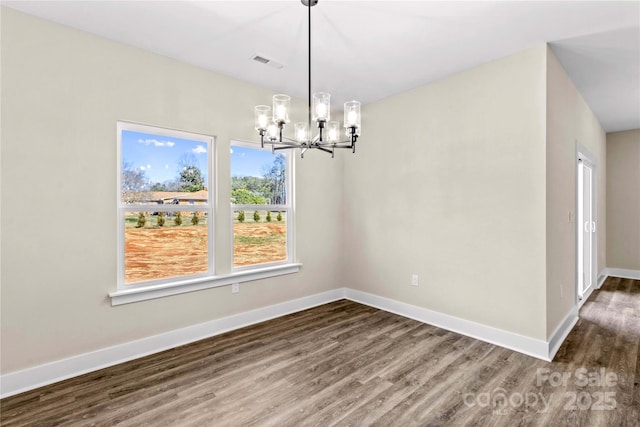 unfurnished dining area with visible vents, baseboards, dark wood-type flooring, and a chandelier