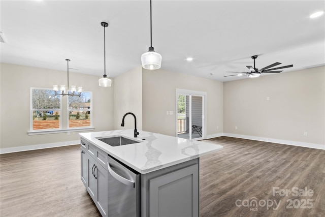 kitchen featuring stainless steel dishwasher, dark wood-type flooring, gray cabinetry, and a sink