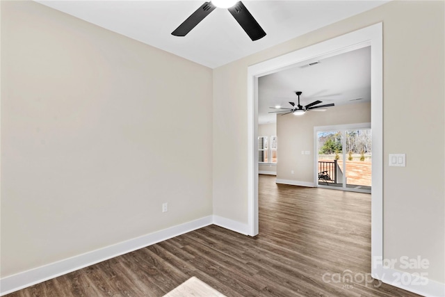 empty room with visible vents, baseboards, a ceiling fan, and dark wood-style flooring